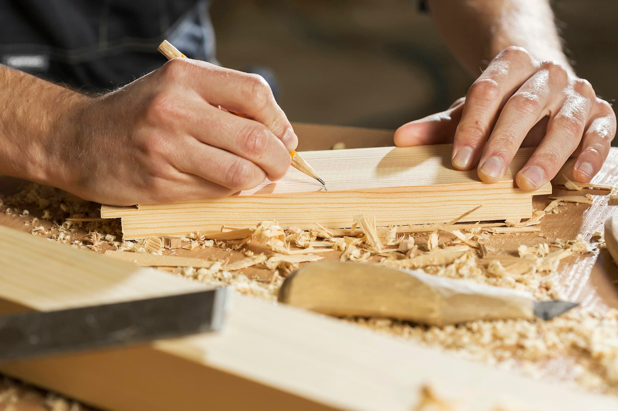 A maker finishing a timber component by hand